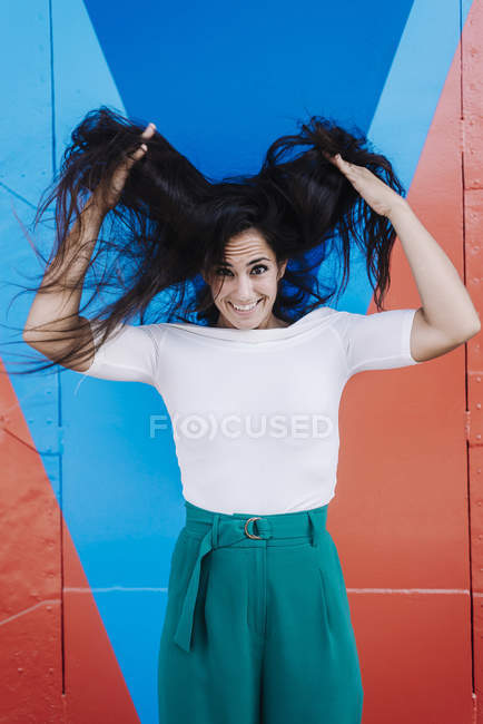 Eine junge Frau hält ihr zerzaustes Haar — Stockfoto