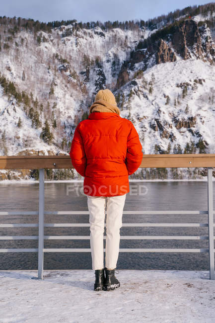 Mulher desfrutando paisagem de rio e montanhas nevadas — Fotografia de Stock