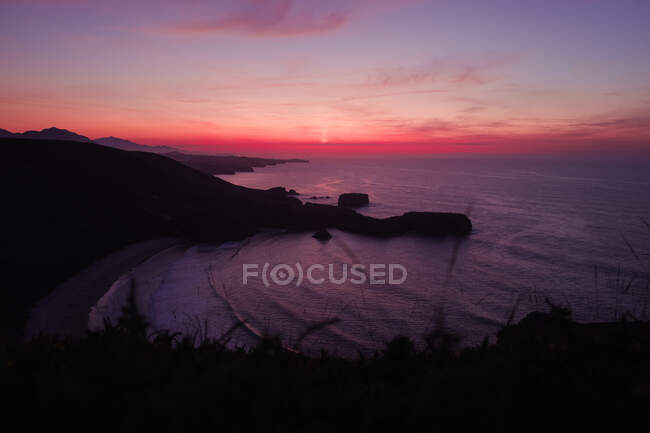 Pôr do sol sobre colinas pitorescas e mar — Fotografia de Stock