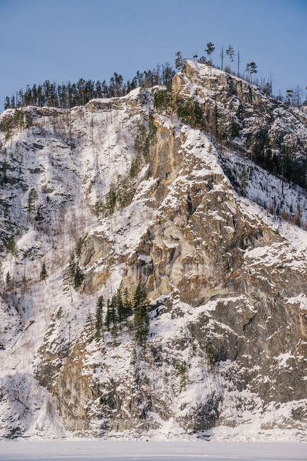 Paysage hivernal avec rochers enneigés et ciel bleu — Photo de stock