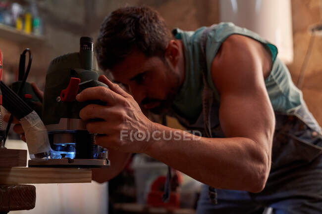 Homme travaillant avec une fraiseuse en atelier — Photo de stock