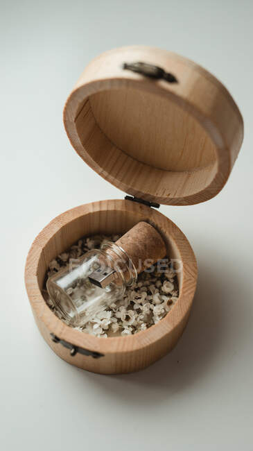 Dall'alto scatola di legno rotonda aperta con piccola chiavetta in confezione unica di bottiglia di vetro — Foto stock