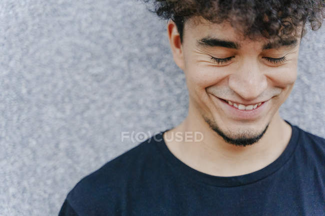 From above of man with Afro hairdo in black t shirt with closed eyes on blurred background — Stock Photo