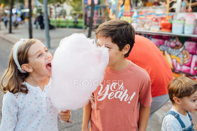 Enfants joyeux appréciant les bonbons sucrés dans la rue — Photo de stock