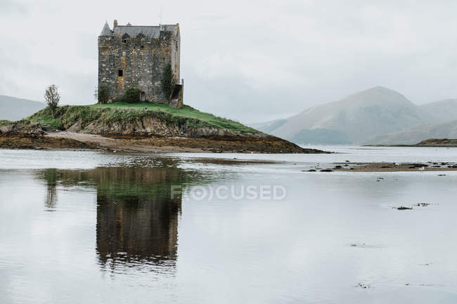Ancien bâtiment de château placé sur une petite île près des montagnes en Écosse — Photo de stock