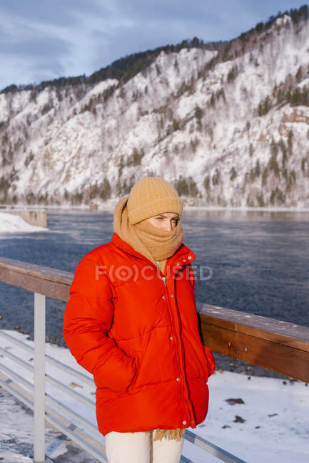 Femme appréciant le paysage de la rivière et des montagnes enneigées — Photo de stock