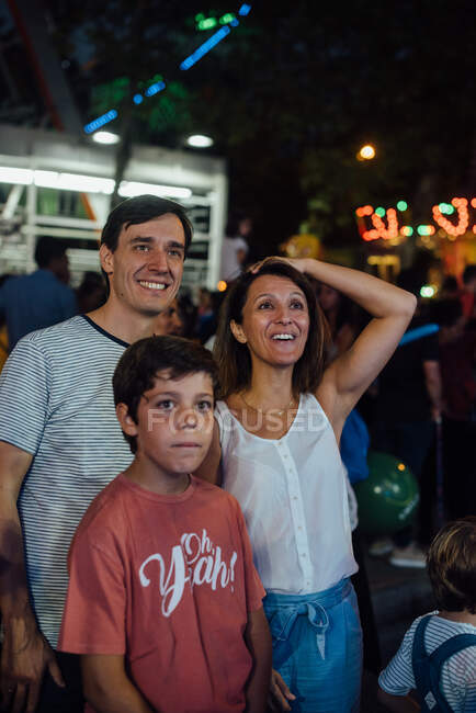 Família alegre no parque de diversões na cidade — Fotografia de Stock