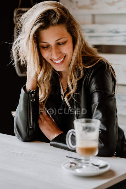 Vista lateral da bela mulher loira sentada em uma loja de café com olhos fechados — Fotografia de Stock