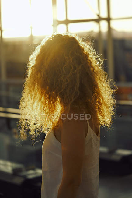 Curly charmante femme marchant dans la chambre vitrée lumière de l'aéroport au Texas — Photo de stock
