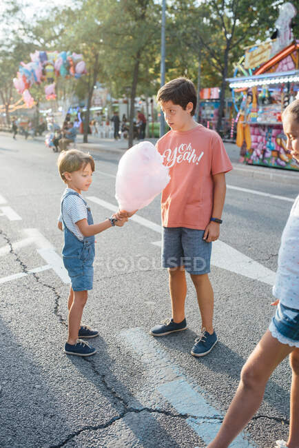 Crianças alegres desfrutando de doces doces na rua — Fotografia de Stock
