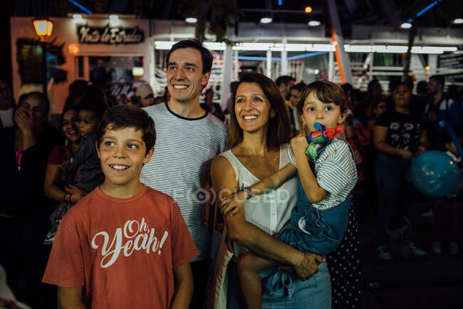 Famille joyeuse sur le terrain de foire en ville — Photo de stock