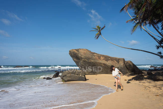 Mujer en ropa de playa caminando sobre arena - foto de stock