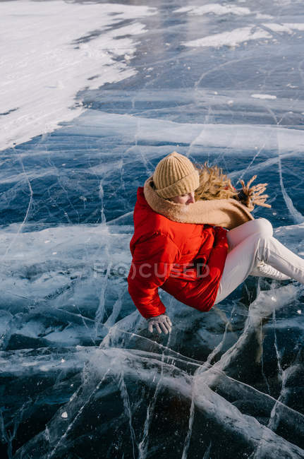 Donna felice in pattini sdraiata sul ghiaccio — Foto stock
