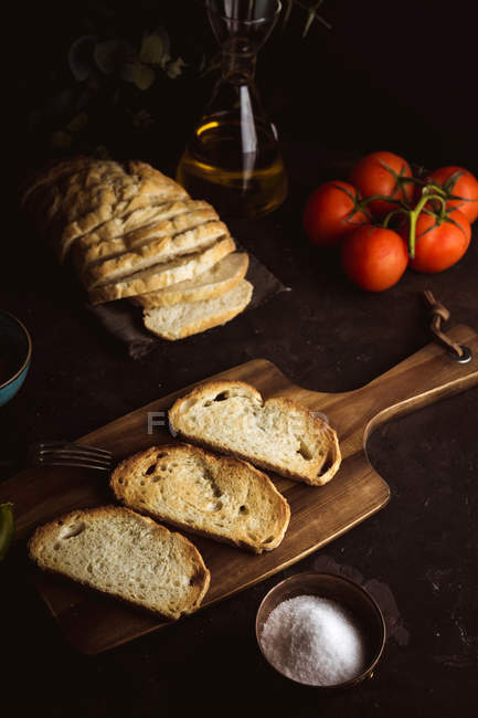 Toast ingredienti su tagliere di legno su tavolo scuro — Foto stock