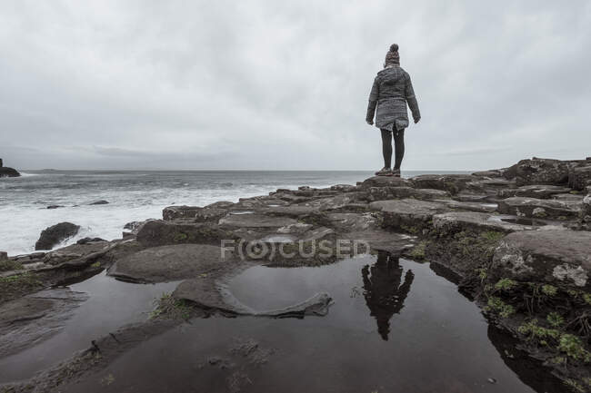 Donna in piedi sulla scogliera e contemplando — Foto stock