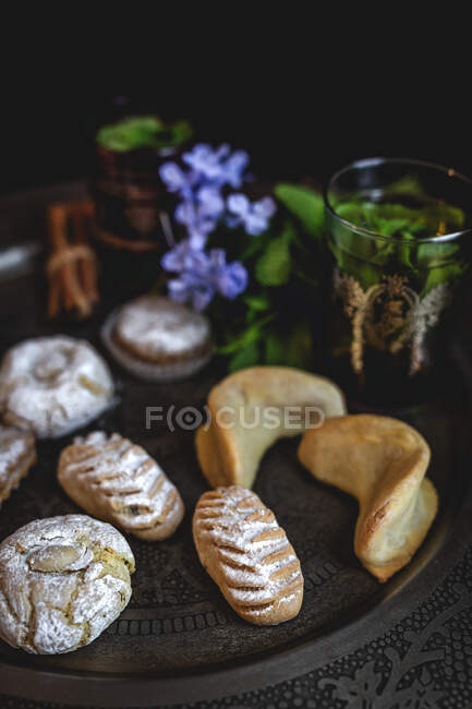 Traditioneller Tee mit Minze und verschiedenen hausgemachten arabischen Süßigkeiten auf dunklem Hintergrund. Ramadan. Islamisch. Halal — Stockfoto