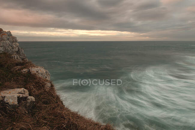 Мощная волна плескается на гранитной скале — стоковое фото
