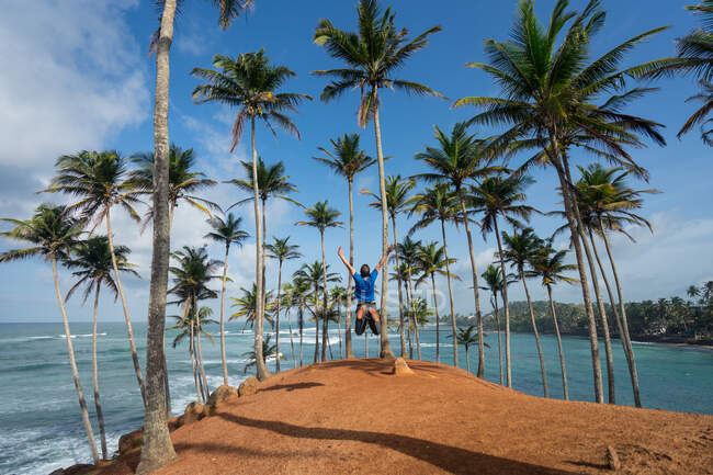 Homem entre palmeiras à beira-mar — Fotografia de Stock