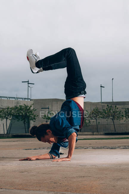 Skillful break dancer performing handstand while moving — culture, fun ...