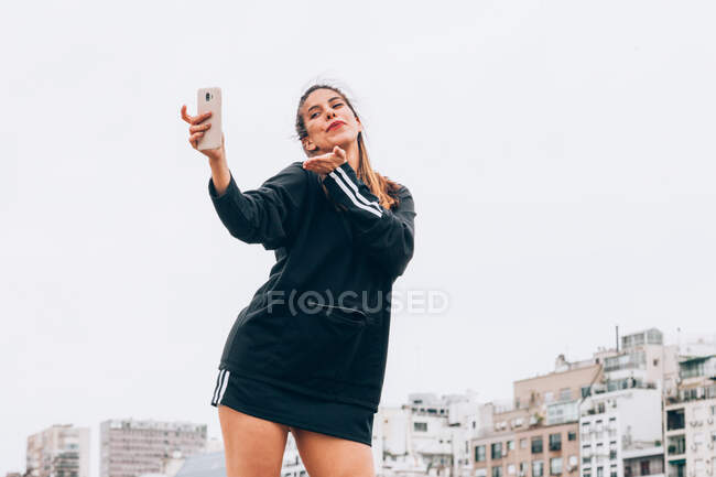 Conteúdo jovem mulher em uso casual tirando selfie na rua da cidade — Fotografia de Stock