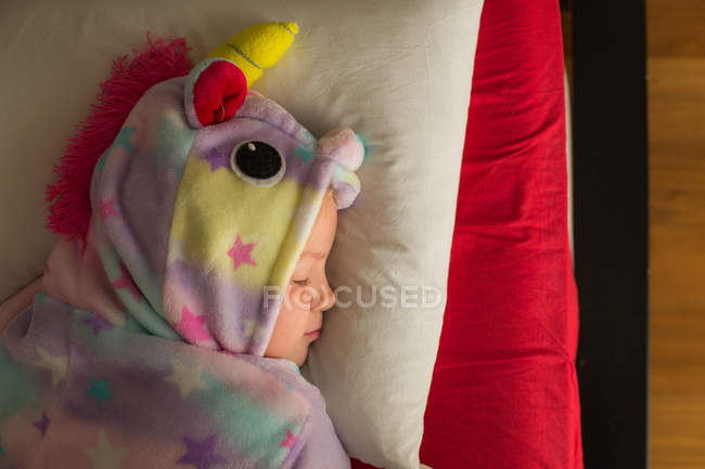 Mädchen im Einhorn-Pyjama schläft zu Hause im Bett — Stockfoto