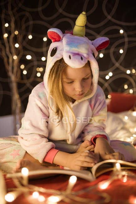 Книга для девочек в спальне украшена рождественскими гирляндами — стоковое фото