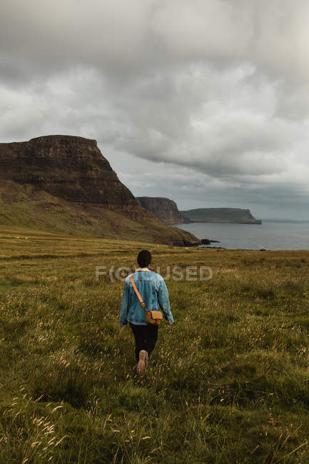 Gelassener Tourist genießt Blick auf ruhiges grünes Tal bei bewölktem Wetter in Schottland — Stockfoto