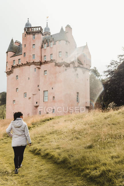 Donna in piedi accanto al castello medievale in Scozia — Foto stock