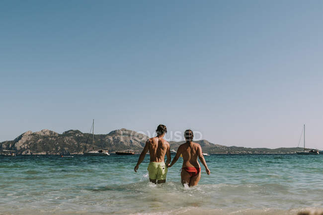 Couple heureux marchant sur la mer — Photo de stock