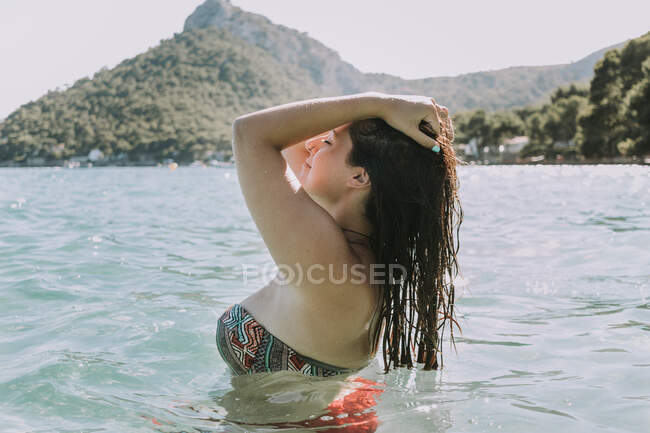 Woman resting in water on seashore — Stock Photo