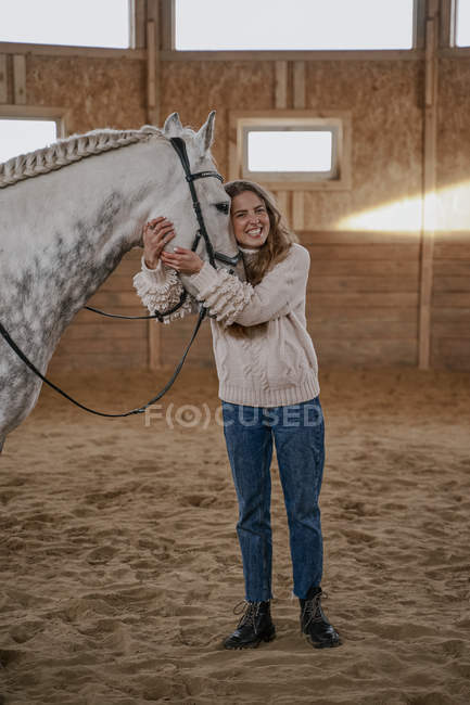 Mulher com cavalo cinza maçã com cauda longa fofo andando ao redor grande arena — Fotografia de Stock