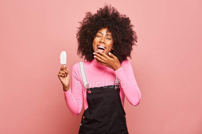 Mulher engraçada com sorvete na vara olhando para a câmera — Fotografia de Stock