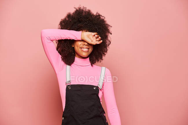 Mujer joven afroamericana cubriendo los ojos con el brazo - foto de stock