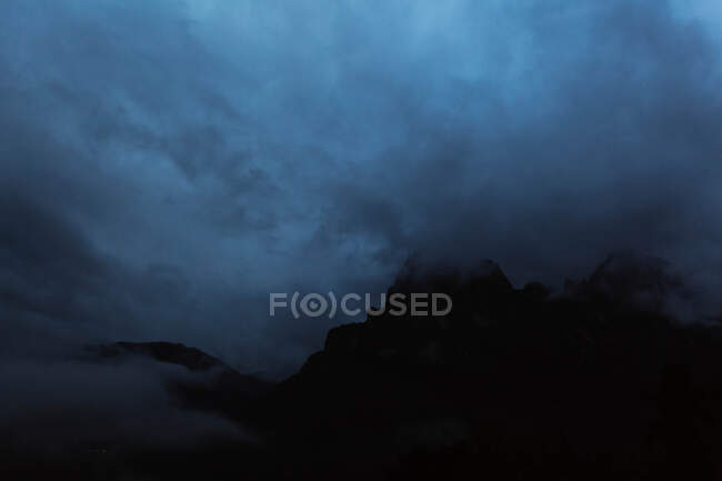Big mountains near pine forest on cloudy weather — Stock Photo