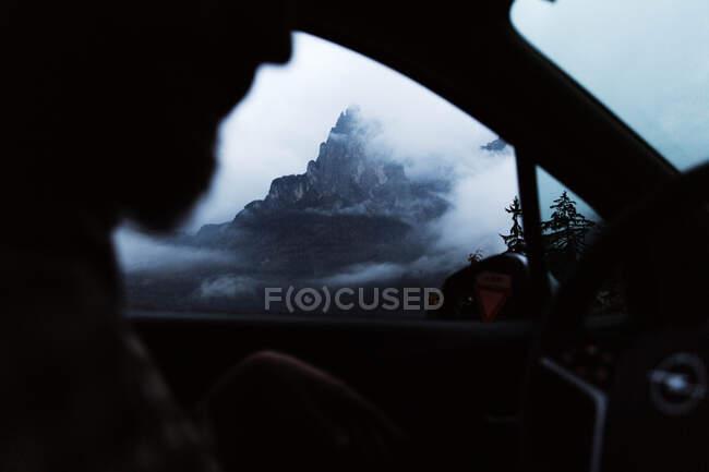 Powerful mountains and cloudy sky view from window of car — Stock Photo