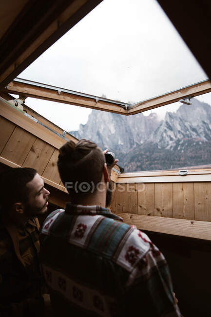 Men in casual wear enjoying views from ceiling window — Stock Photo