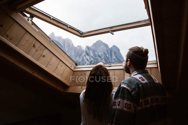Liebendes Paar in Freizeitkleidung genießt Aussicht aus dem Deckenfenster — Stockfoto