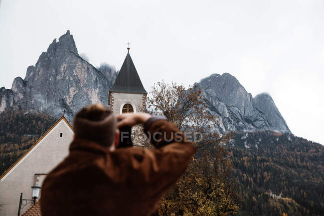 Männlicher Reisender fotografiert Natur und Kirche vor der Kamera — Stockfoto