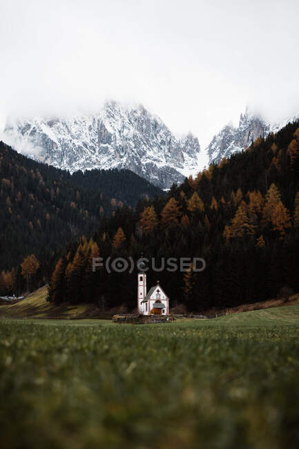 Small church on cliff near forest and mountains — Stock Photo