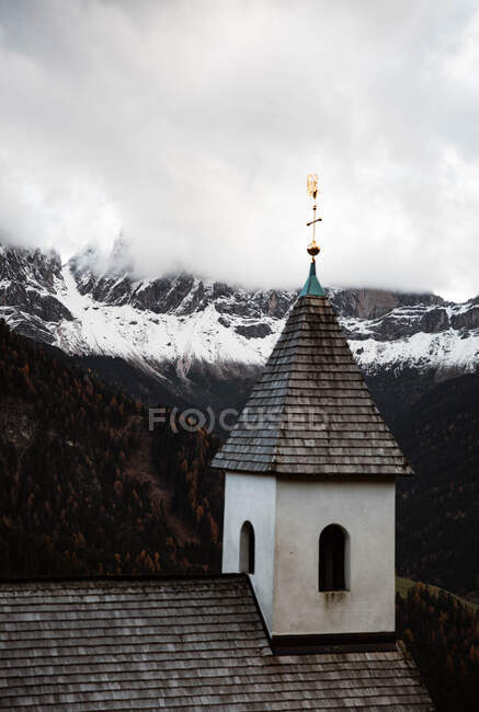 Pequena igreja em penhasco perto de floresta e montanhas — Fotografia de Stock