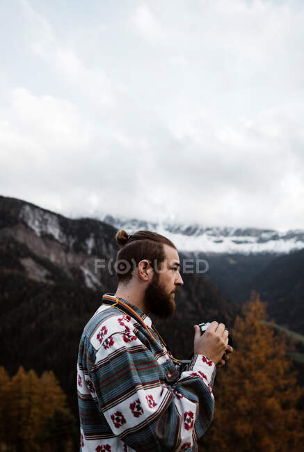 El hombre deleitándose con las vistas del bosque y las montañas - foto de stock