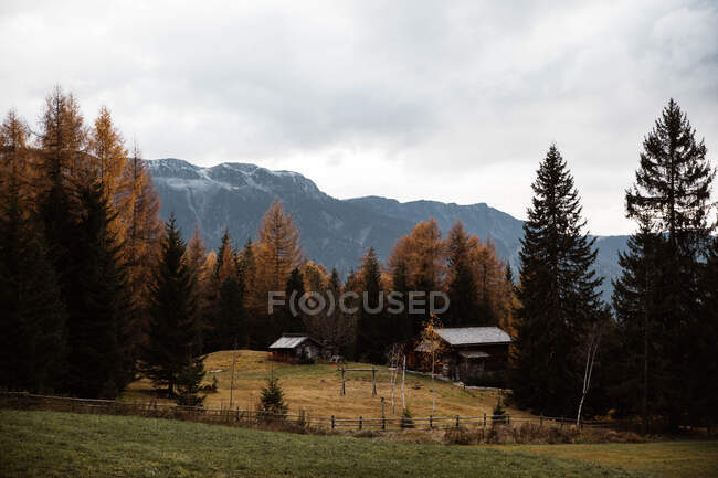 Lonely house in field by mountain — Stock Photo