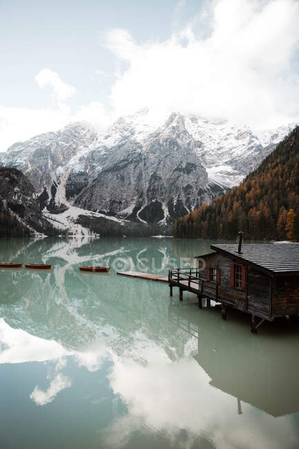 Casa su palafitte sul lago vicino alle montagne — Foto stock