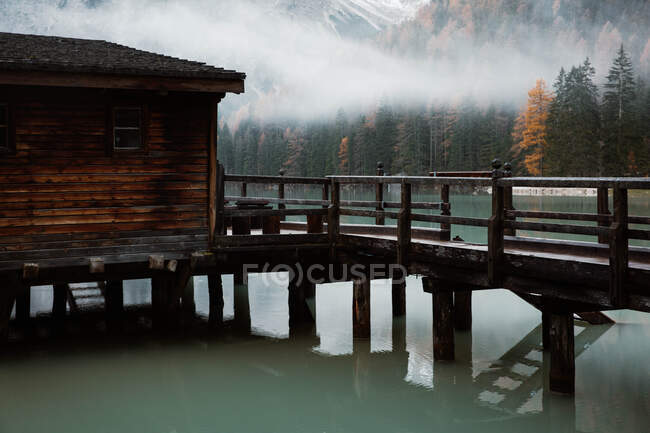 Casa em palafitas em lago perto de montanhas — Fotografia de Stock