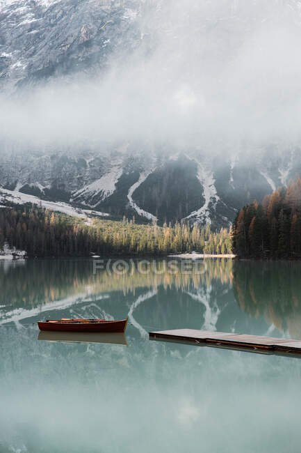 Beautiful lake with boast with mountains behind — Stock Photo