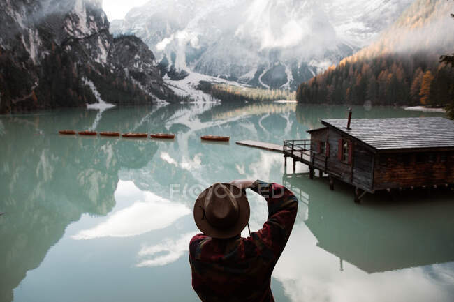 Ruhender Mann in Freizeitkleidung erfreut sich an der Aussicht in der Nähe von See und Mou — Stockfoto