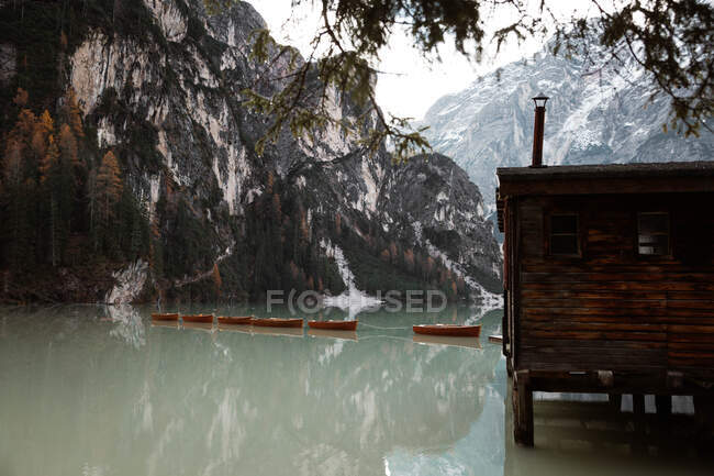 Дом на сваях на озере возле гор — стоковое фото