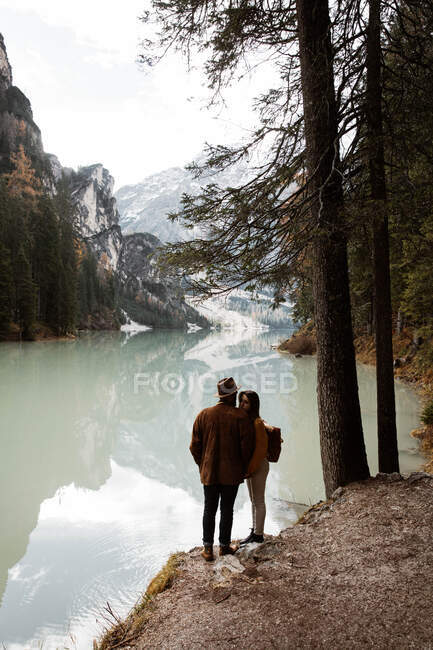 Отдыхающая пара наслаждается видом на озеро и горы — стоковое фото