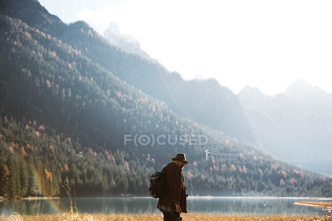 Homem deliciando-se com vistas perto do lago e das montanhas — Fotografia de Stock