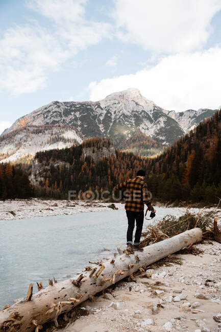 Homem deliciando-se com vistas perto do lago e das montanhas — Fotografia de Stock